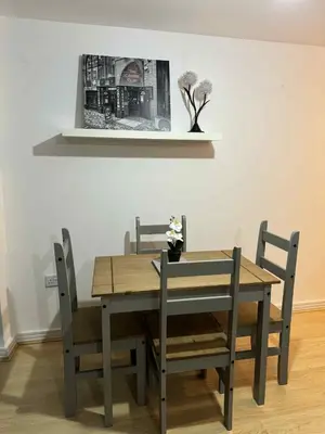 a dining room table and chairs with a picture on the wall at City Centre Apartment in Liverpool