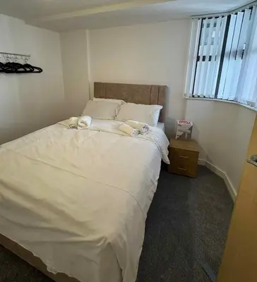 a bedroom with a bed with two stuffed animals on it at City Centre Apartment in Liverpool