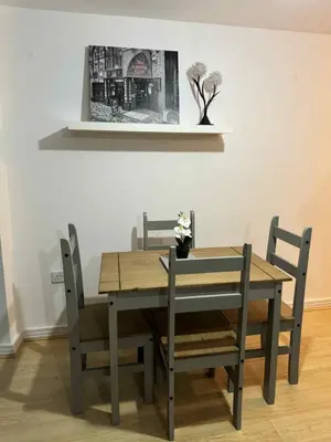 a dining room table and chairs with a picture on the wall at City Centre Apartment in Liverpool
