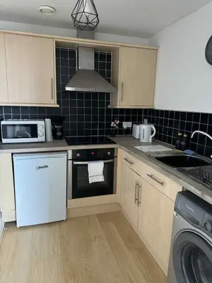 a kitchen with a sink and a stove top oven at City Centre Apartment in Liverpool