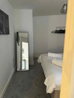 a room with two beds and a mirror in it at City Centre Apartment in Liverpool
