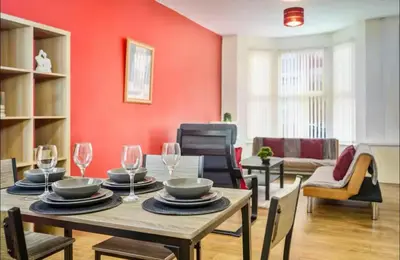 a dining room with a table and chairs at The Red Retreat, 7 Beds, Garden, Free Parking, Contractors, Fast Wifi, Smart TV in Liverpool