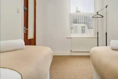 a room with two beds and a window at The Red Retreat, 7 Beds, Garden, Free Parking, Contractors, Fast Wifi, Smart TV in Liverpool
