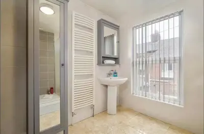 a bathroom with a sink and a mirror at The Red Retreat, 7 Beds, Garden, Free Parking, Contractors, Fast Wifi, Smart TV in Liverpool