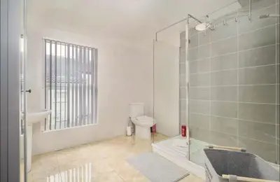 a bathroom with a shower and a toilet and a sink at The Red Retreat, 7 Beds, Garden, Free Parking, Contractors, Fast Wifi, Smart TV in Liverpool