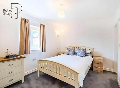 a bedroom with a bed and a dresser and a window at No 6 PolkaStays Ivy Farm Orchard Suite in Plumpton