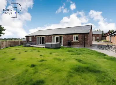 a house with a large green lawn in front of it at No 6 PolkaStays Ivy Farm Orchard Suite in Plumpton