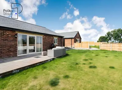 a house with a lawn in front of it at No 6 PolkaStays Ivy Farm Orchard Suite in Plumpton