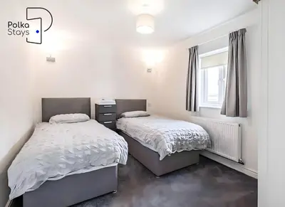 a bedroom with two beds and a window at No 6 PolkaStays Ivy Farm Orchard Suite in Plumpton