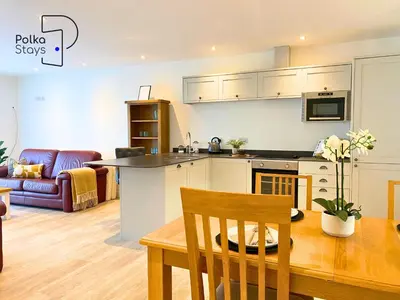 a kitchen and living room with a table and a dining room at No 6 PolkaStays Ivy Farm Orchard Suite in Plumpton
