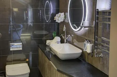 a bathroom with a sink and a toilet and mirrors at The Eccleston Hotel; BW Signature Collection in Saint Helens