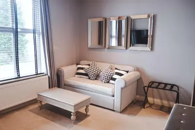 a living room with a couch and a mirror at The Eccleston Hotel; BW Signature Collection in Saint Helens