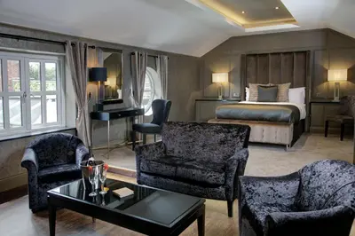 a hotel room with a bed and a living room at The Eccleston Hotel; BW Signature Collection in Saint Helens