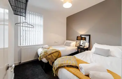 a bedroom with two beds and a window at Infinity St Ives Grove- With Street Parking in Liverpool