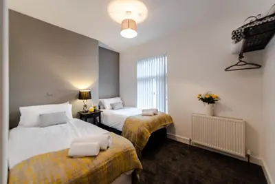 a hotel room with two beds and a window at Infinity St Ives Grove- With Street Parking in Liverpool