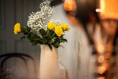 a white vase filled with yellow flowers on a table at Infinity St Ives Grove- With Street Parking in Liverpool