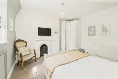 a bedroom with a bed and a chair and a tv at Host & Stay - Beech Street in Liverpool