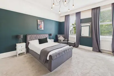 a bedroom with a bed and a blue wall at Host & Stay - Beech Street in Liverpool