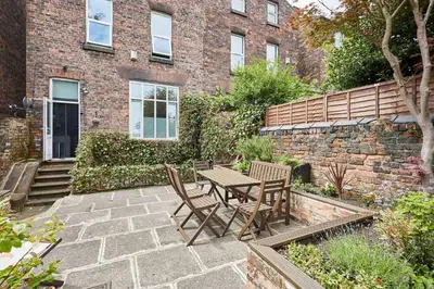 a patio with a table and chairs in front of a brick building at Host & Stay - Beech Street in Liverpool
