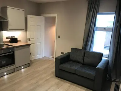 a living room with a couch and a kitchen at Central 1 bed stylish apartment in Barrow in Furness