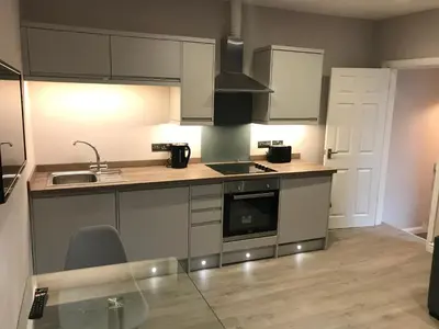 a kitchen with a sink and a stove top oven at Central 1 bed stylish apartment in Barrow in Furness