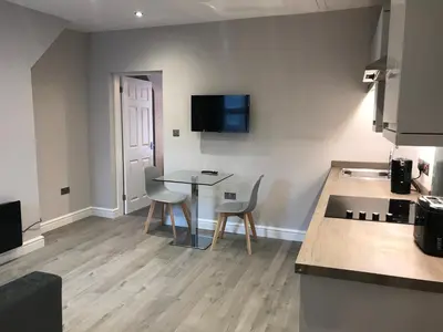 a kitchen with a table and two chairs and a counter at Central 1 bed stylish apartment in Barrow in Furness