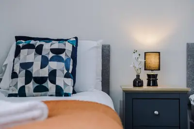 a bedroom with a bed with a pillow and a nightstand at Anfield Nest - Air Host & Stay - 3 bed 3 bath in Liverpool