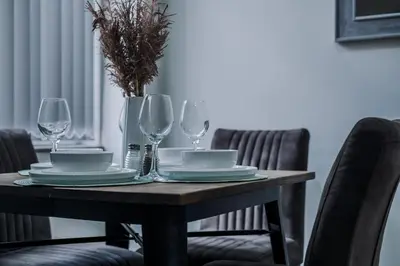 a dining room table with plates and wine glasses at Anfield Nest - Air Host & Stay - 3 bed 3 bath in Liverpool