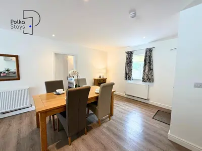 a dining room with a wooden table and chairs at No 8 PolkaStays Ivy Farm Primrose Deluxe in Brown Moss Side