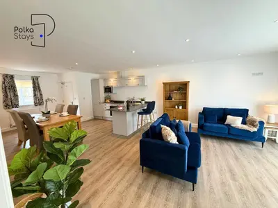 a living room with two blue couches and a kitchen at No 8 PolkaStays Ivy Farm Primrose Deluxe in Brown Moss Side