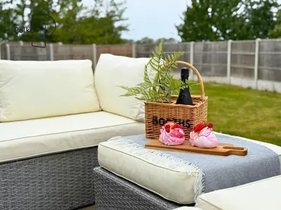 a wicker table with a basket and two pink shoes at No 8 PolkaStays Ivy Farm Primrose Deluxe in Brown Moss Side