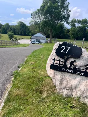 a sign on a rock next to a road at Thwaite Croft - Carnforth in Carnforth