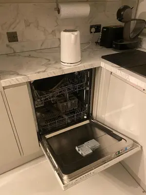 an open dishwasher in a kitchen with a roll of paper towels at Twinhorse in Prescot
