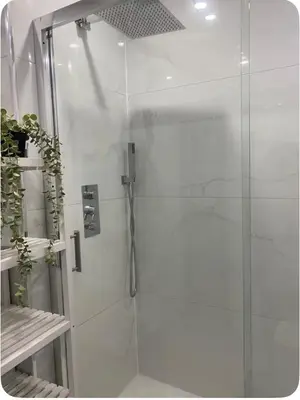 a shower with a glass door in a bathroom at Twinhorse in Prescot