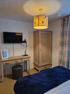 a bedroom with a bed and a desk with a television at 2 bed GF Docklands Apartment - Free Parking for 1 car in Liverpool