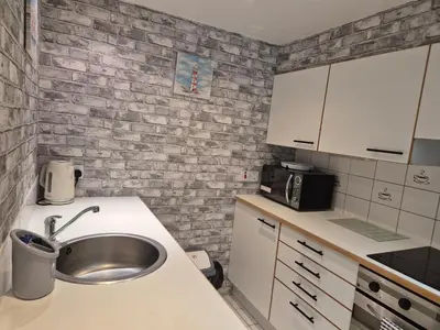 a kitchen with a sink and a brick wall at 2 bed GF Docklands Apartment - Free Parking for 1 car in Liverpool