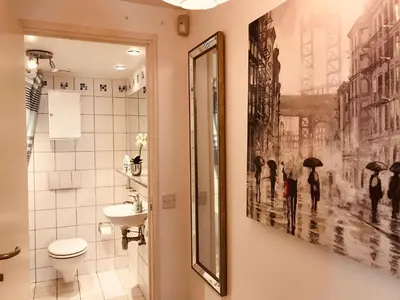 a bathroom with a picture of people with umbrellas at 2 bed GF Docklands Apartment - Free Parking for 1 car in Liverpool