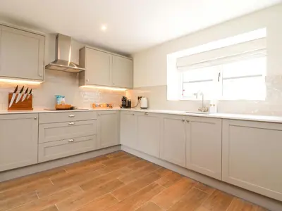 a kitchen with white cabinets and a window at Heron View in Preston