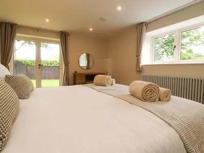 a bedroom with a large white bed with a window at Heron View in Preston