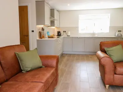 a living room with two couches and a kitchen at Heron View in Preston