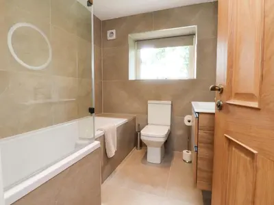a bathroom with a toilet and a tub and a sink at Heron View in Preston