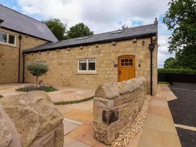 a stone building with a stone wall in front of it at Heron View in Preston