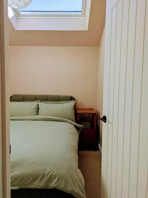 a bedroom with a bed with a window above it at Field Edge Barn in Silverdale