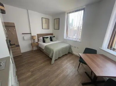 a bedroom with a bed and a table and a desk at Central 1-Bed Studio Sleeps 2 with City Views in Liverpool