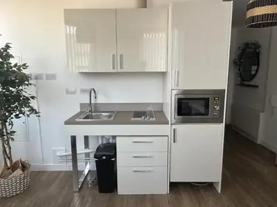 a white kitchen with a sink and a microwave at Central 1-Bed Studio Sleeps 2 with City Views in Liverpool