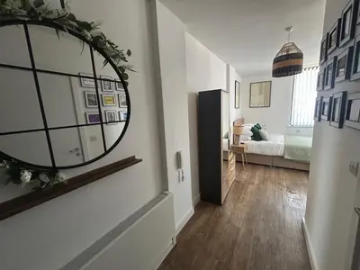 a hallway with a mirror and a room with a bed at Central 1-Bed Studio Sleeps 2 with City Views in Liverpool