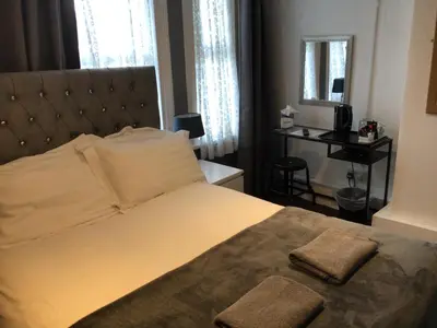 a bedroom with a large bed with two towels on it at White Swallow Hotel in Blackpool