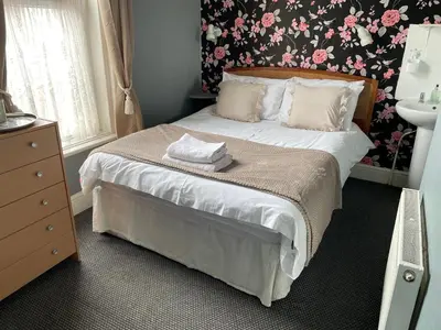 a bedroom with a bed with a floral wallpaper at Somerville Hotel in Blackpool