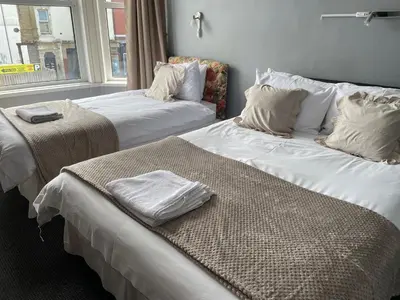 two beds sitting next to each other in a room at Somerville Hotel in Blackpool