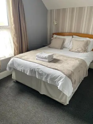 a bedroom with a bed with two towels on it at Somerville Hotel in Blackpool